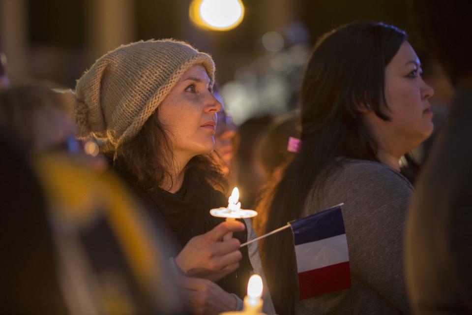 A woman holds a French flag at a memorial and vigil outside City Hall for the victims of the Paris attacks, on Nov. 17, 2015, in Los Angeles. Southern California resident Nohemi Gonzalez was among those killed in the attacks.