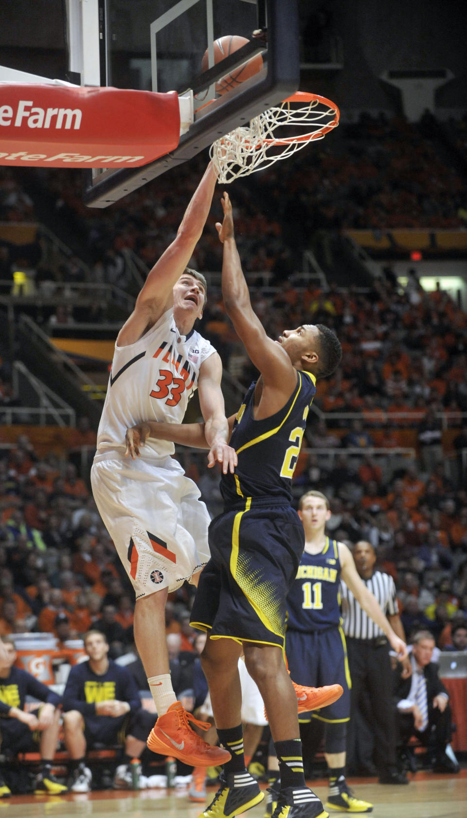 Illinois forward Jon Ekey (33) misses a dunk against Michigan guard Zak Irvin (21) during the first half of an NCAA college basketball game Tuesday, March 4, 2014, in Champaign, Ill. (AP Photo/Rick Danzl)