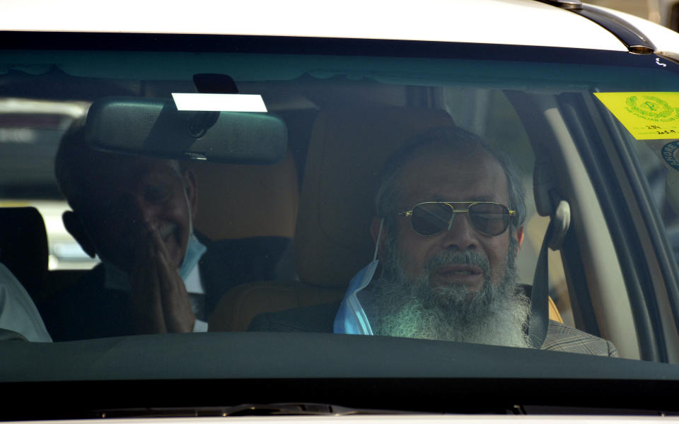 Ahmed Saeed Sheikh, right, father of British-born Pakistani Ahmed Omar Saeed Sheikh, leaves the Supreme Court with his lawyer Mehmood A. Sheikh, after an appeal hearing in the Daniel Pearl murder case, in Islamabad, Pakistan, Thursday, Jan. 28, 2021. The court on Thursday ordered the release of Ahmed Omar Saeed Sheikh, who was convicted and later acquitted in the gruesome beheading of American journalist Pearl in 2002. The court also dismissed an appeal of Sheikh's acquittal by Pearl's family. (AP Photo/Waseem Khan)