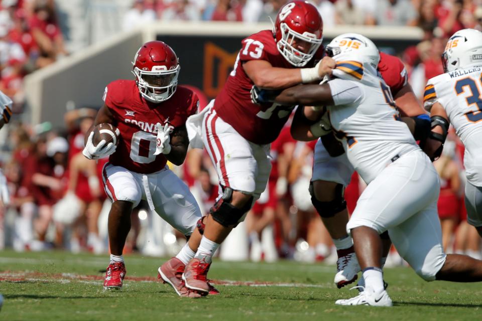 OU's Eric Gray (0) runs the ball behind Andrew Raym (73) in a 45-13 win against UTEP on Sept. 3 in Norman.
