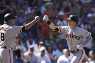 San Francisco Giants' Mike Yastrzemski, right, is greeted by third base coach Ron Wotus after hitting a two-run home run during the second inning of a baseball game against the San Diego Padres, Thursday, Sept. 23, 2021, in San Diego. (AP Photo/Gregory Bull)