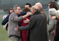 Released French hostage Didier Francois, left, is welcomed by his family upon arrival at the Villacoublay military airbase, outside Paris, Sunday April 20, 2014. Francois and three other French journalists kidnapped and held for 10 months in Syria returned home on Sunday to joyful families awaiting them. The four were freed by their captives a day earlier at the Turkish border. (AP Photo/Jacques Brinon)