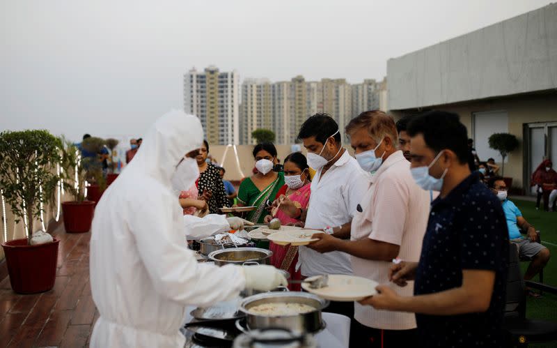 Hospital staff serve food to the patients suffering from the coronavirus disease (COVID-19) during an evening buffet at a hospital in Noida