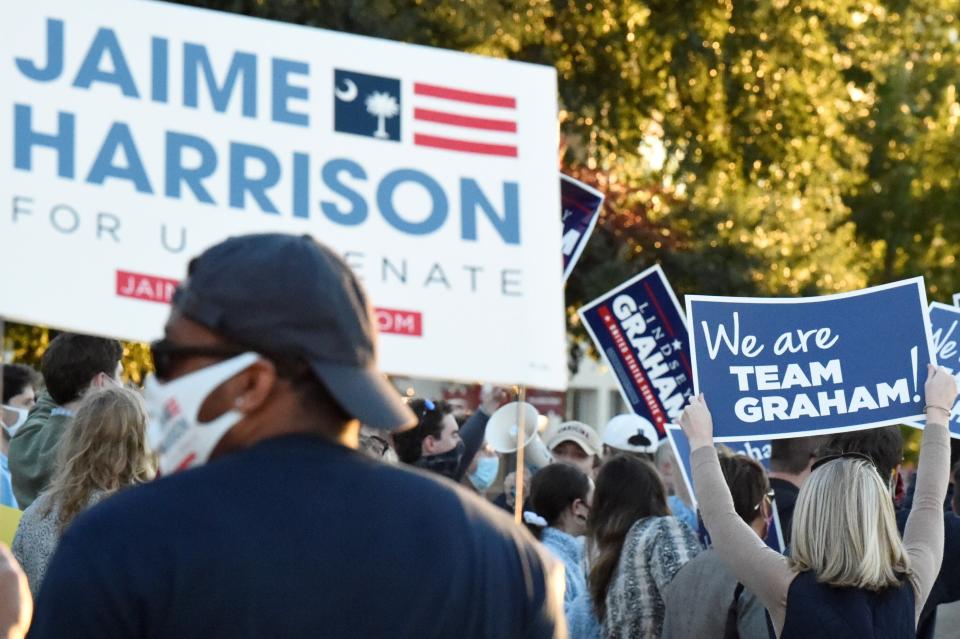 Supporters wave signs and chant outside the final debate between U.S. Sen. Lindsey Graham of South Carolina and Democratic challenger Jaime Harrison on Friday, Oct. 30, 2020, in Columbia, S.C. (AP Photo/Meg Kinnard)