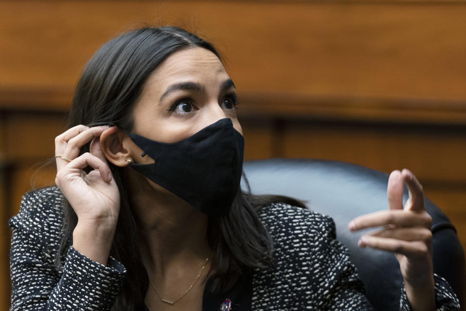 Rep. Alexandria Ocasio-Cortez, D-N.Y. talks to an aide during a House Committee on Oversight and Reform hearing on the Capitol breach on Capitol Hill, Wednesday, May 12, 2021, Washington. (AP Photo/Manuel Balce Ceneta)