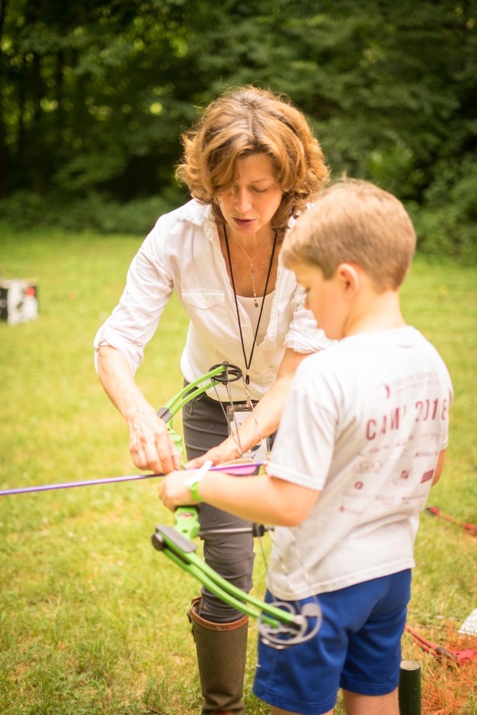A 2019 picture of Amy Grant teaching archery at Barefoot at the Farm, a Christian day camp held on Grant's Williamson County farm each summer. The camp aims to bring together children of different races, economic levels and cultures. Half the camp's spots are reserved for children from low-income families.