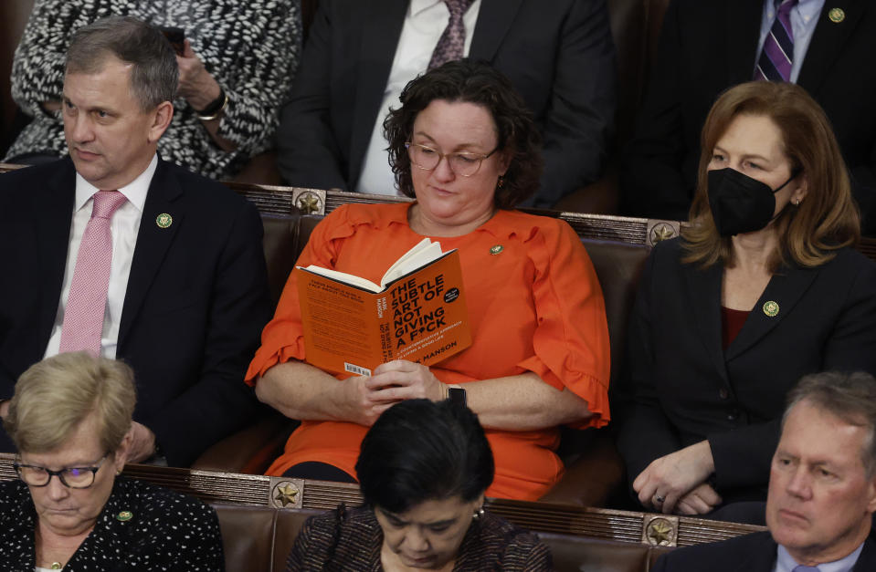 Rep. Katie Porter (D-CA) reads on the floor during the 14th roll call vote Friday