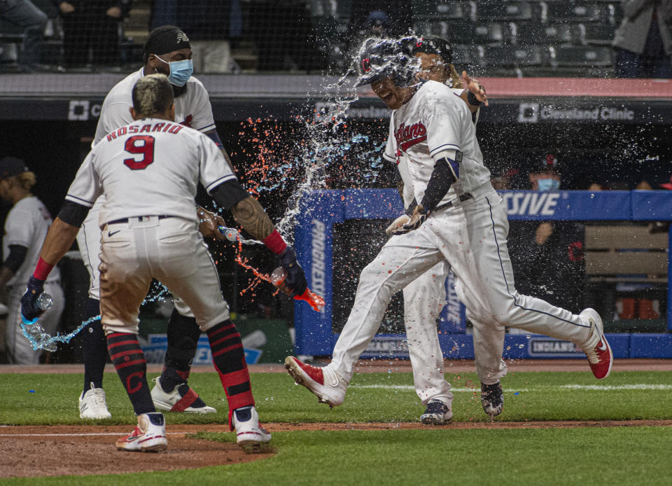 Cleveland Indians' Jordan Luplow gets drenched by Eddie Rosario and his teammates after hitting a two-run home run off Minnesota Twins relief pitcher Alex Colome during the tenth inning of a baseball game in Cleveland, Monday, April 26, 2021. (AP Photo/Phil Long)