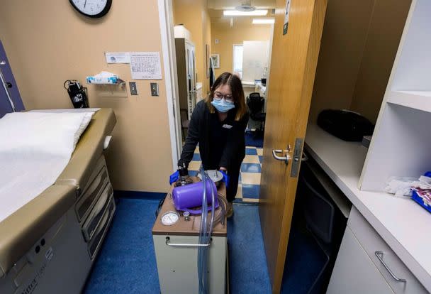 PHOTO: A lab assistant transports a suction machine into a patient room, on July 7, 2022, at WE Health Clinic in Duluth, Minn. (Derek Montgomery/AP)