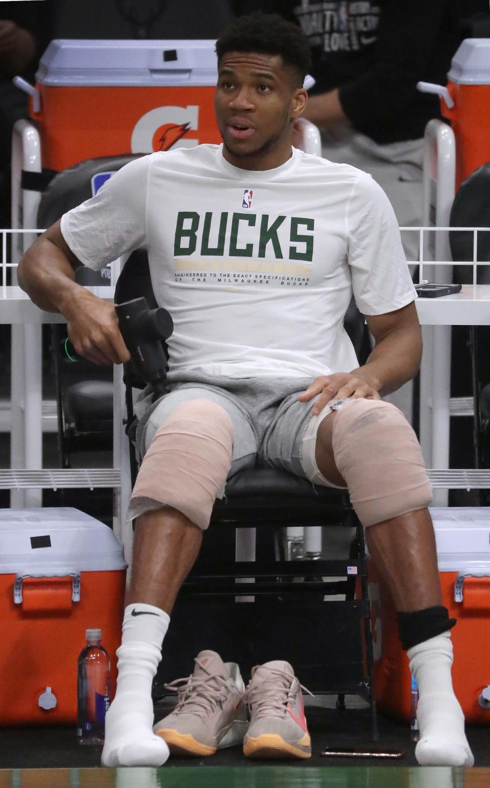 With his knees wrapped with ice bags, Milwaukee Bucks forward Giannis Antetokounmpo watches the end of practice Tuesday, July 13, 2021.