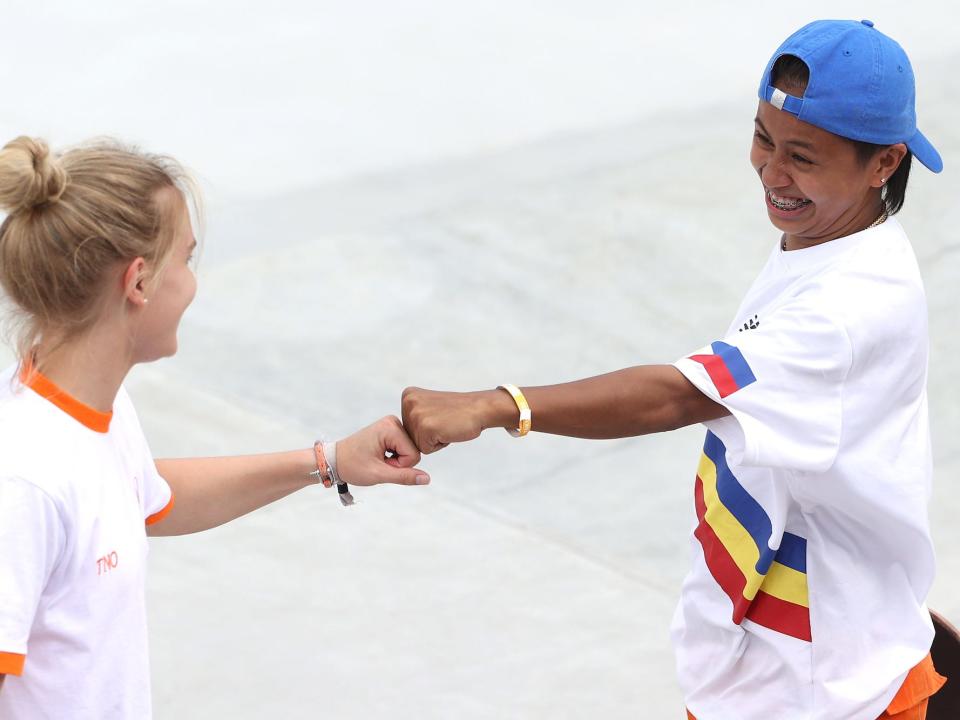 Roos Zwetsloot of the Netherlands fist bumps Margielyn Didal thr Team Philippines during the women's street skate