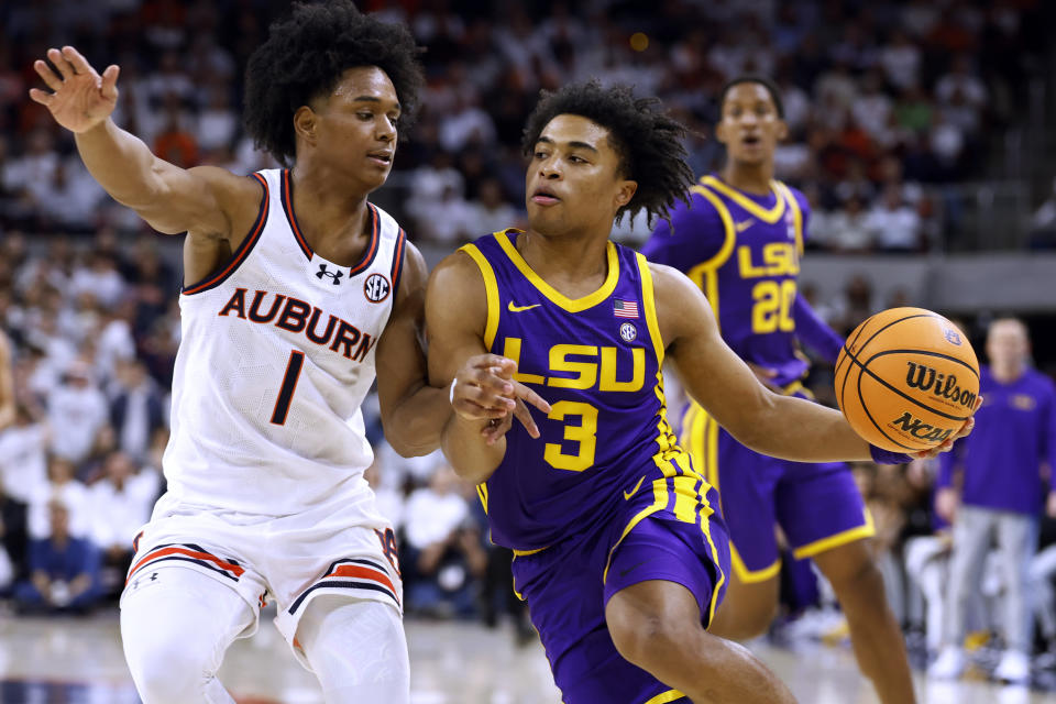 LSU guard Jalen Cook (3) drives against Auburn guard Aden Holloway (1) during the first half of an NCAA college basketball game Saturday, Jan. 13, 2024, in Auburn, Ala. (AP Photo/Butch Dill)