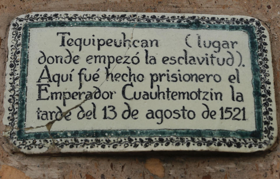 A plaque reads in Spanish "Tequipeuhcan: The place where slavery began. Here the Emperor Cuauhtemotzin was taken prisoner on the afternoon of Aug. 13, 1521" at the La Concepcion Tequipeuhcan Church in Mexico City, Tuesday, May 18, 2021. Cuauhtemotzin was the last Aztec Emperor who ascended to the throne while Tenochtitlan was being besieged by the Spanish and devastated by an epidemic of smallpox brought by Spanish explorers. He was eventually defeated, captured, tortured and executed by the Spaniards. (AP Photo/Eduardo Verdugo)