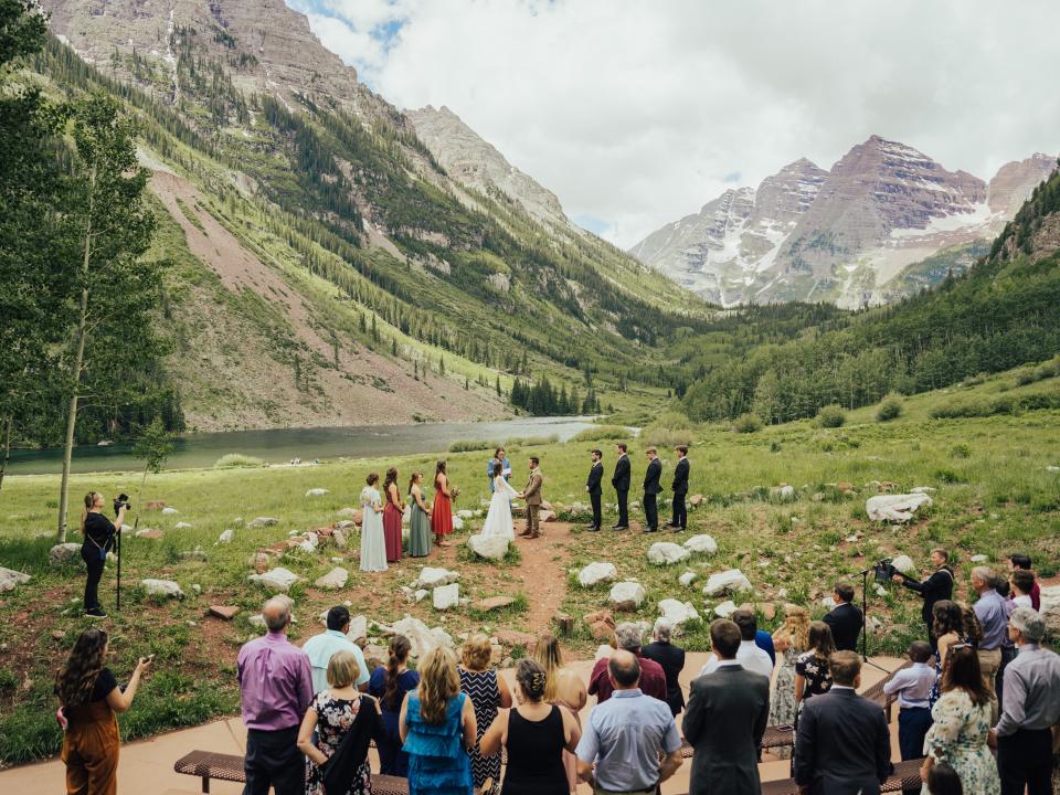 abi and her husband getting married in maroon bells amphitheater with their bridal party and wedding guests