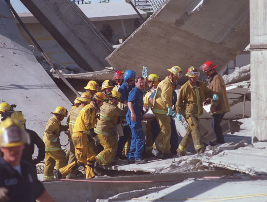 SF.Recover.1.0415.BYNORTHRIDGEFire Dept. Urban Search and Rescue team members carry Salvador Pena (cq) away from collapsed garage at Northridge Fashion Center where he had been trapped after structure fell on him during 1994 earthquake. (Photo by Boris Yaro/Los Angeles Times via Getty Images)