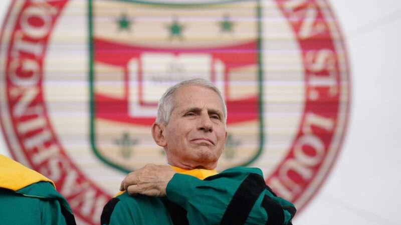 Retired Director of the National Institutes of Health Anthony Fauci adjusts his robe before receiving an honorary degree from Washington University.