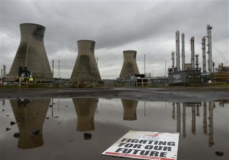 A placard floats in a puddle in a car park in front of the Grangemouth refinery in Scotland October 21, 2013. REUTERS/Russell Cheyne