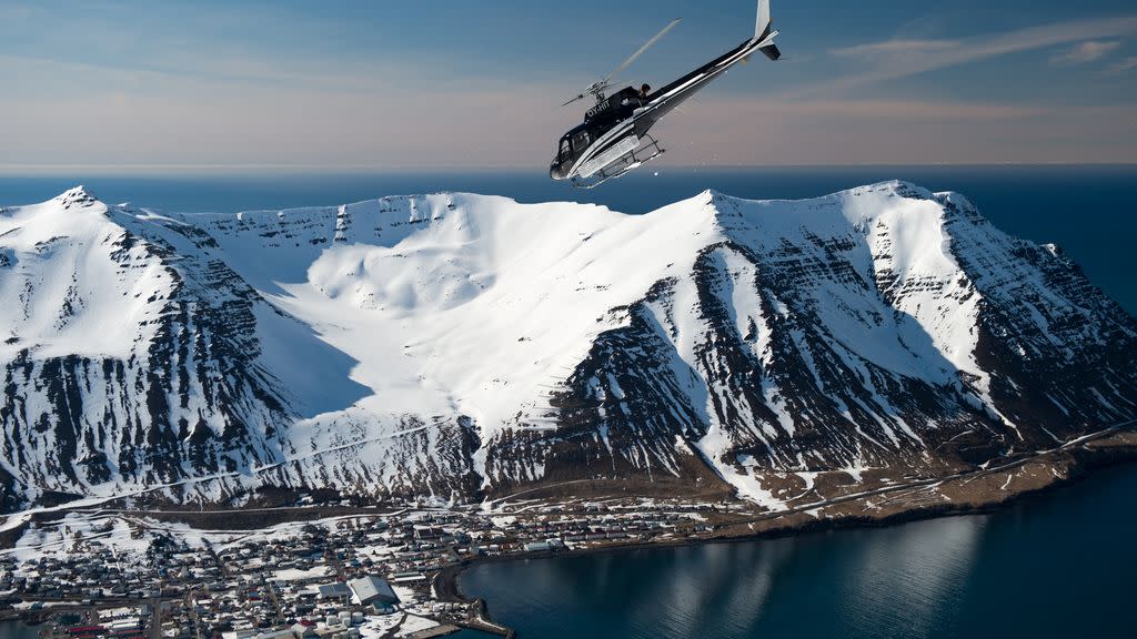 a helicopter flying over a snowy mountain