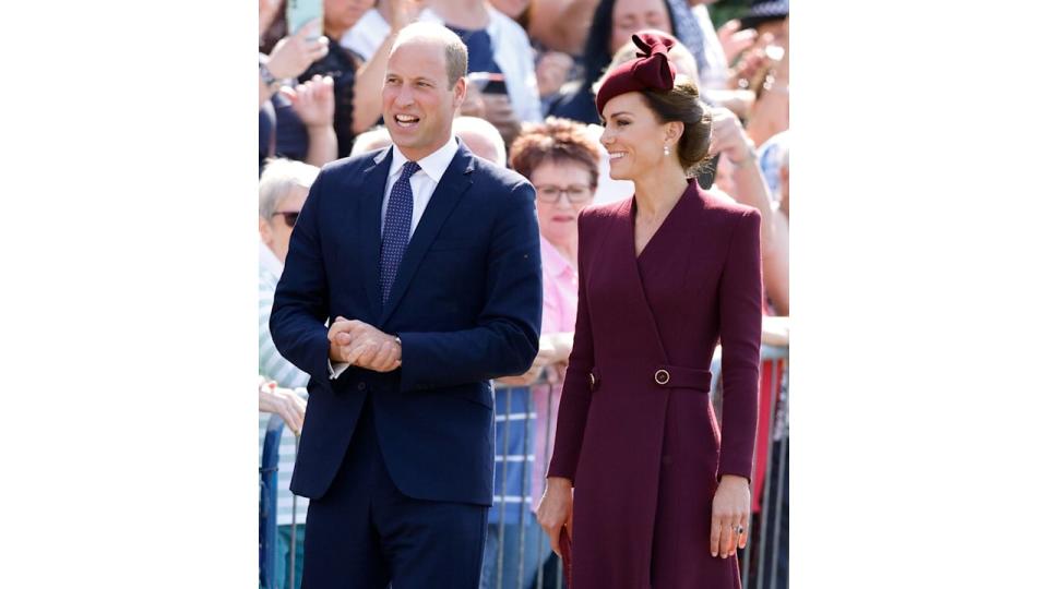 Prince William in a suit and Kate Middleton in a burgundy dress