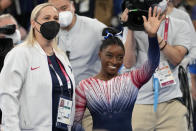 Simone Biles, of the United States, waves standing next to her coach Cecile Landi after performing on the balance beam during the artistic gymnastics women's apparatus final at the 2020 Summer Olympics, Tuesday, Aug. 3, 2021, in Tokyo, Japan. (AP Photo/Ashley Landis)