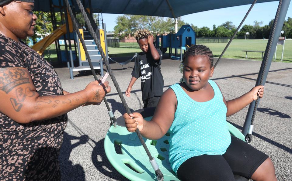 Shenika Collins plays with her kids, 7-year-old A'Layah Powell and 10-year-old Myron Scott, on the Hope Place family shelter playground one morning last week. Collins was a lifelong Fort Myers resident until Hurricane Ian hit last year and she wound up homeless.
