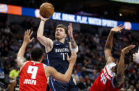 Dallas Mavericks guard Luka Doncic (77) attempts a shot as Sacramento Kings guard Cory Joseph (9) and forward Harrison Barnes (40) defend during the first half of an NBA basketball game, Wednesday, Feb. 12, 2020, in Dallas. (AP Photo/Brandon Wade)