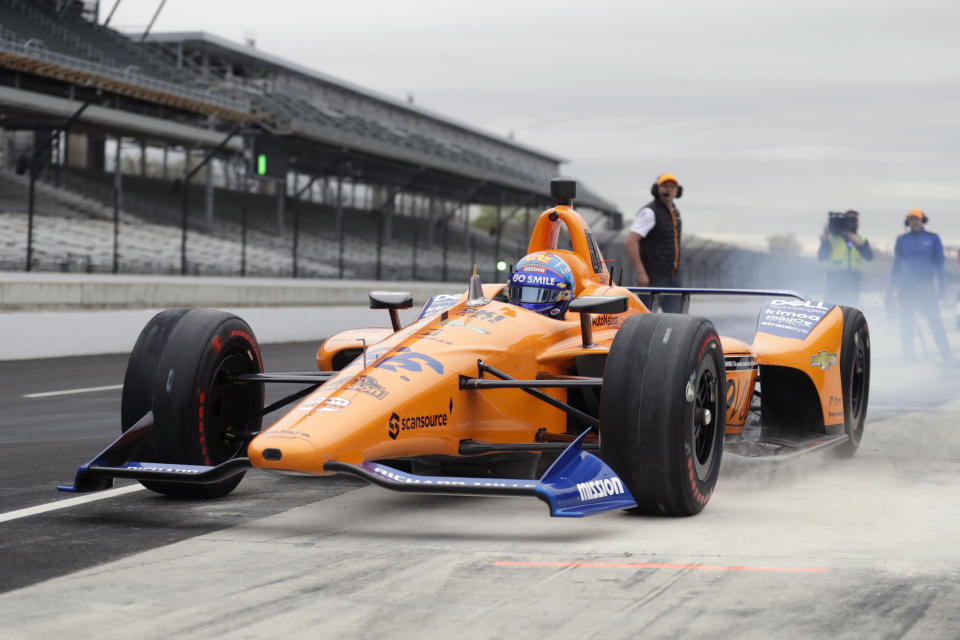 FILE - In this April 24, 2019, file photo, IndyCar driver Fernando Alonso, of Spain, drives out of the pit area during testing at the Indianapolis Motor Speedway in Indianapolis. Alonso will once again attempt to complete motorsports' version of the Triple Crown with a return to the Indianapolis 500 in May with McLaren. (AP Photo/Michael Conroy, File)