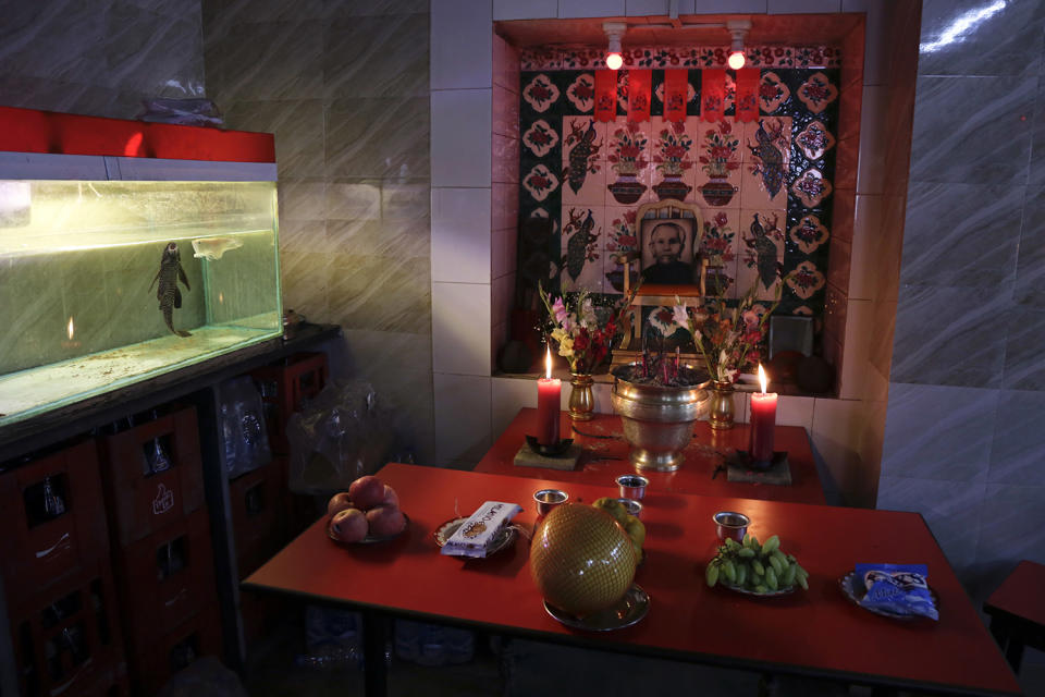 Offerings are set on a prayer altar before the portrait of a deceased relative inside a restaurant on the first day of Chinese lunar new year in Kolkata, India, Saturday, Jan. 28, 2017. Chinese around the world are celebrating this year's Year of the Rooster according to the Chinese zodiac calendar. (AP Photo/Bikas Das)