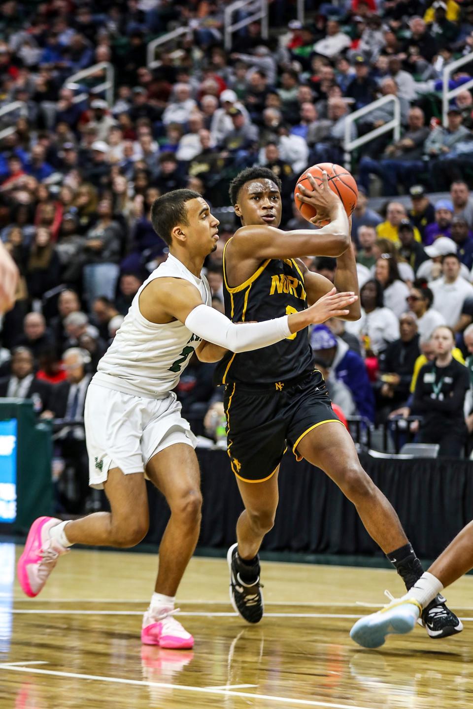 North Farmington’s Tyler Spratt drives the lane with the ball against Zeeland West’s Khi Anderson during North Farmington's 58-39 win in the MHSAA Division 1 boys basketball semifinals on Friday, March 15, 2024, at Breslin Center.