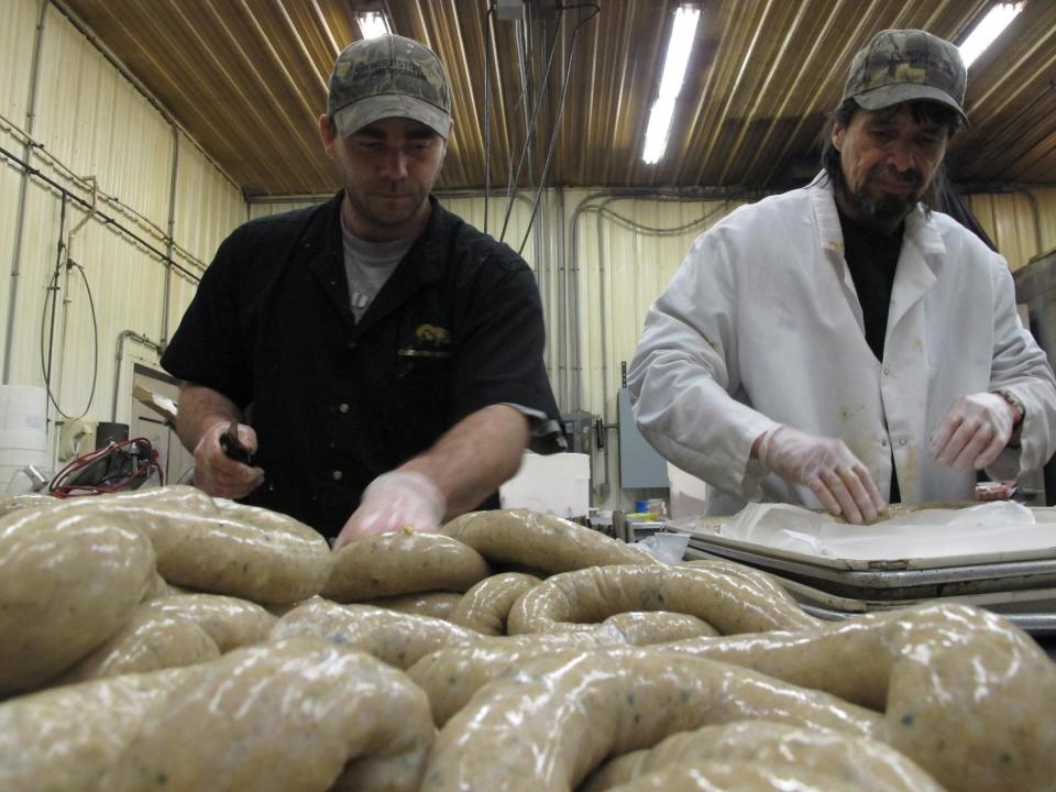 In this Wednesday, April 10, 2013 photo, processing department workers Chris Cote, left, and William Brooks at the Country Store market prepare links of boudin to be sold in the meat counter in Pennsdale, Pa. The sausage is popular in Louisiana. An influx of workers from the South to fill jobs in the natural gas industry in north-central Pennsylvania has led area catering businesses, restaurants and grocery stores to offer more Southern cuisine like jambalaya and boudin. (AP Photo/Genaro C. Armas)