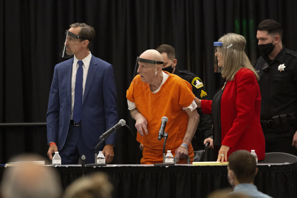 Joseph James DeAngelo, center, charged with being the Golden State Killer, his helped up by his attorney, Diane Howard, as Sacramento Superior Court Judge Michael Bowman enters the courtroom in Sacramento, Calif. Monday June 29, 2020. DeAngelo, 74, is expected to plead guilty 40 years after a sadistic series of assaults and slayings in California. Due to the large numbers of people attending, the hearing was held at a ballroom at California State University, Sacramento to allow for social distancing. (AP Photo/Rich Pedroncelli)