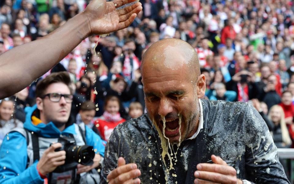 El entrenador español del Bayern de Múnich, Pep Guardiola, recibe una ducha de cerveza mientras el equipo celebra ganar su título número 25 de la Bundesliga - AFP/Christof Stache