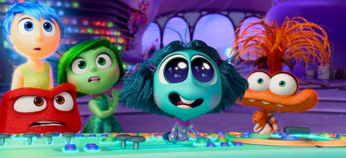 Joy, Disgust, Anger, Sadness, and Fear from Inside Out 2 are seen in front of a control panel, showing concerned and curious expressions
