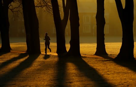 FILE PHOTO: A woman runs through Victoria Park at sunrise in Leicester