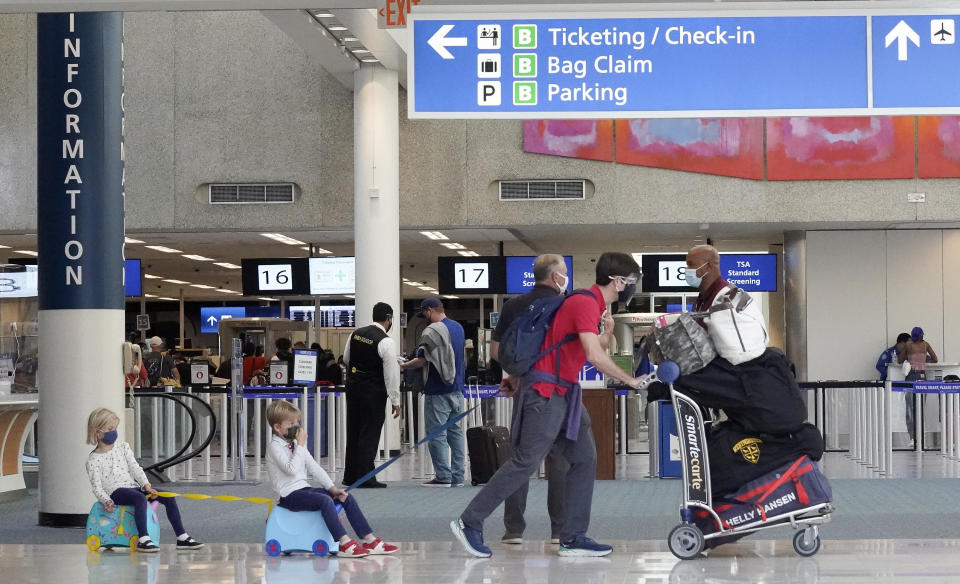 Holiday travelers make their way through Orlando International Airport Tuesday, Nov. 24, 2020, in Orlando, Fla. (AP Photo/John Raoux)