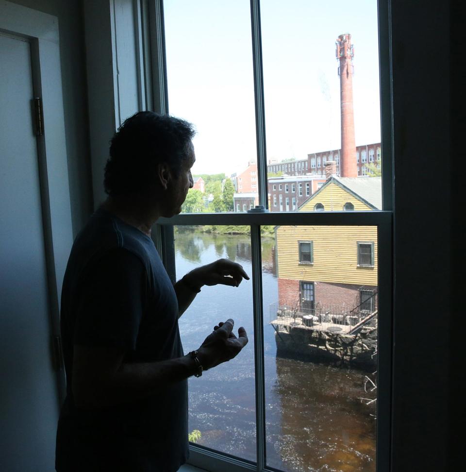 Keith Lemerise, owner of Water Street Marketplace, looks out a window of one of the rooms at the Exeter River.