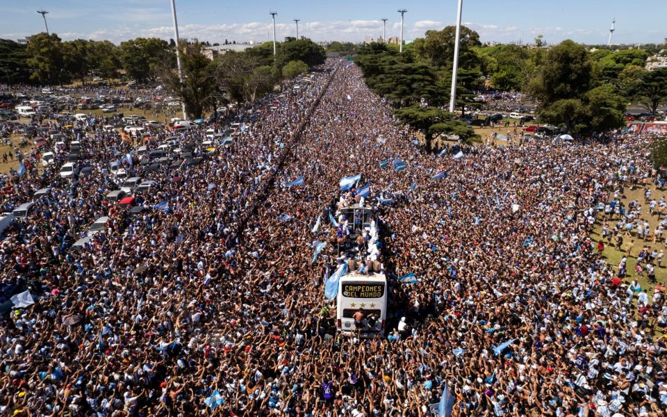 El equipo de fútbol argentino que ganó el título de la Copa del Mundo viaja en un autobús abierto durante su desfile de bienvenida en Buenos Aires, Argentina - AP