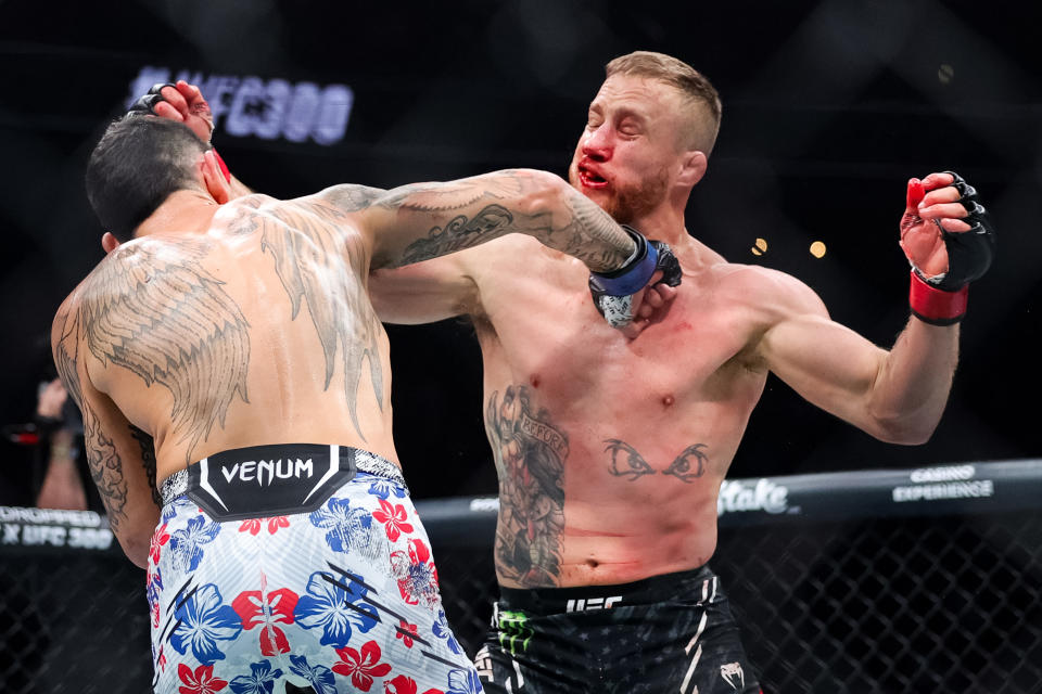 LAS VEGAS, NEVADA - APRIL 13: Justin Gaethje and Max Holloway exchange strikes during their BMF title fight at T-Mobile Arena on April 13, 2024 in Las Vegas, Nevada. (Photo by Carmen Mandato/Getty Images)