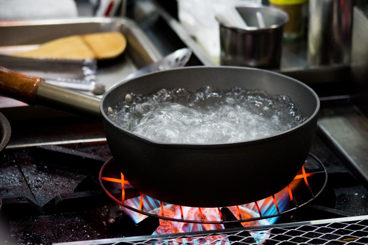 Chef cooking food, Preparation of soup in silver pan on gas, Kitchenware cooking