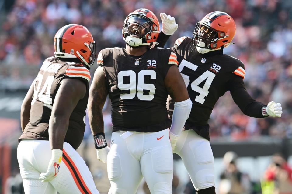 Cleveland Browns defensive tackle Jordan Elliott (96) celebrates a sack with defensive tackle Dalvin Tomlinson (94) and defensive end Ogbo Okoronkwo (54) against the Arizona Cardinals on Sunday in Cleveland.