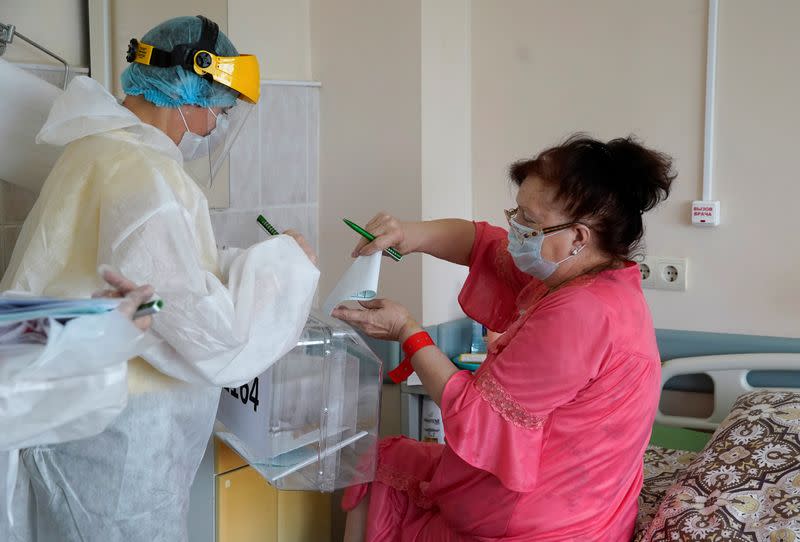 Members of an electoral commission visit a regional hospital during a nationwide vote on constitutional reforms in Tver