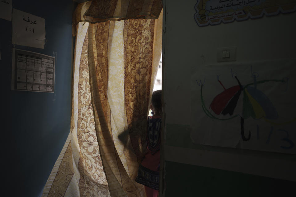 Ghazzal Abu Muawad, 10, peers out of the classroom in a school, located in Gaza's Jabaliya refugee camp on Thursday, June 10, 2021, where her family took shelter after their home was destroyed during an 11-day war between Israel and the Hamas militants who control Gaza. (AP Photo/Felipe Dana)