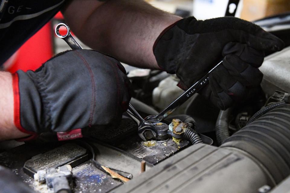 SHIFT Garage volunteer Greg Matson cleans a battery port on a donated car on Wednesday, January 12, 2022, in Sioux Falls.