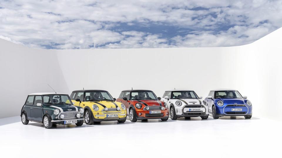 historic mini cooper lineup in a rainbow of colors all lined up in a photo studio