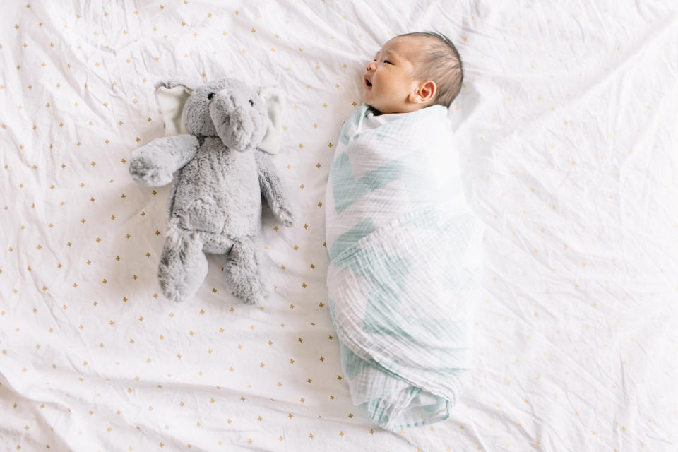 A swaddled baby in crib