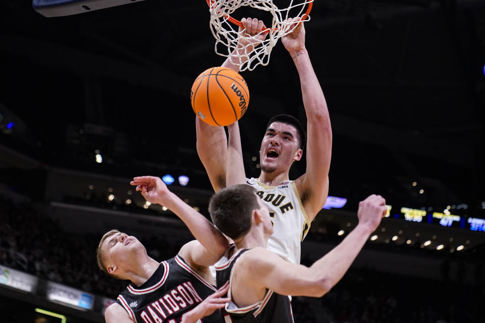 Purdue center Zach Edey (15) gets a dunk over Davidson forward David Skogman, left, and forward Sean Logan in the first half of an NCAA college basketball game in Indianapolis, Saturday, Dec. 17, 2022. (AP Photo/Michael Conroy)