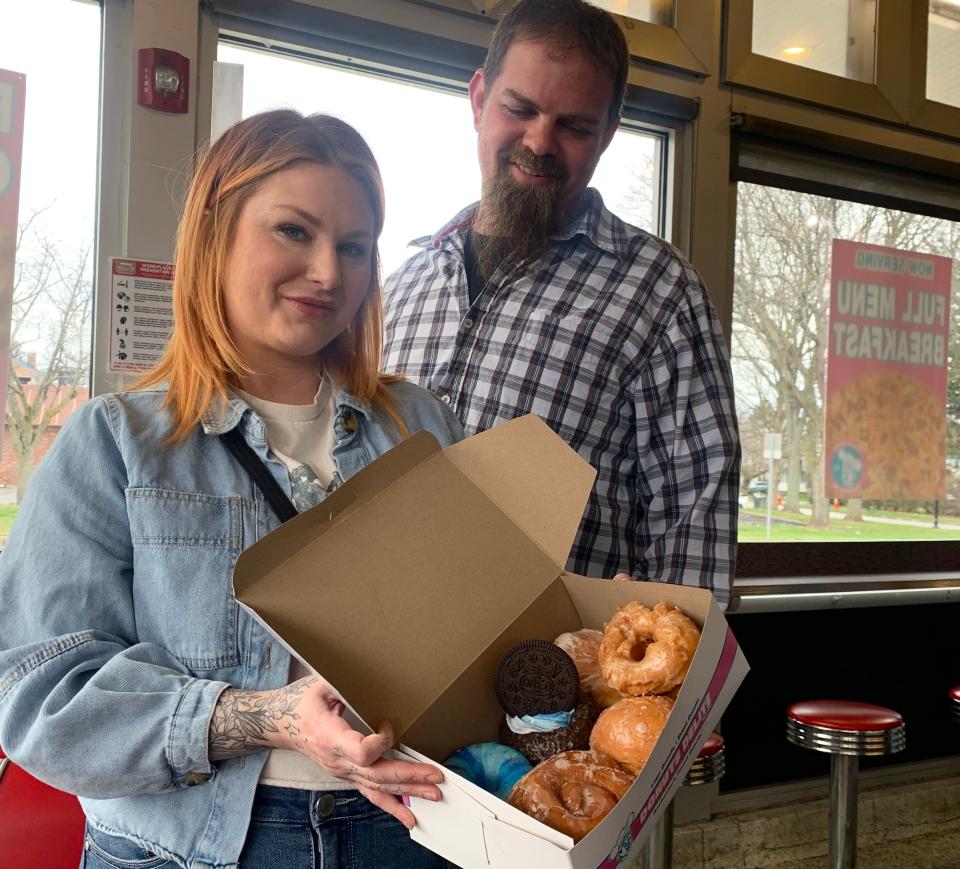 Brittnay Henderson, of Rochester, and Jeremy Klace of the Buffalo area show off their Donuts Delite haul, including Galaxy and Solar Eclipse doughnuts, on April 8, 2024.