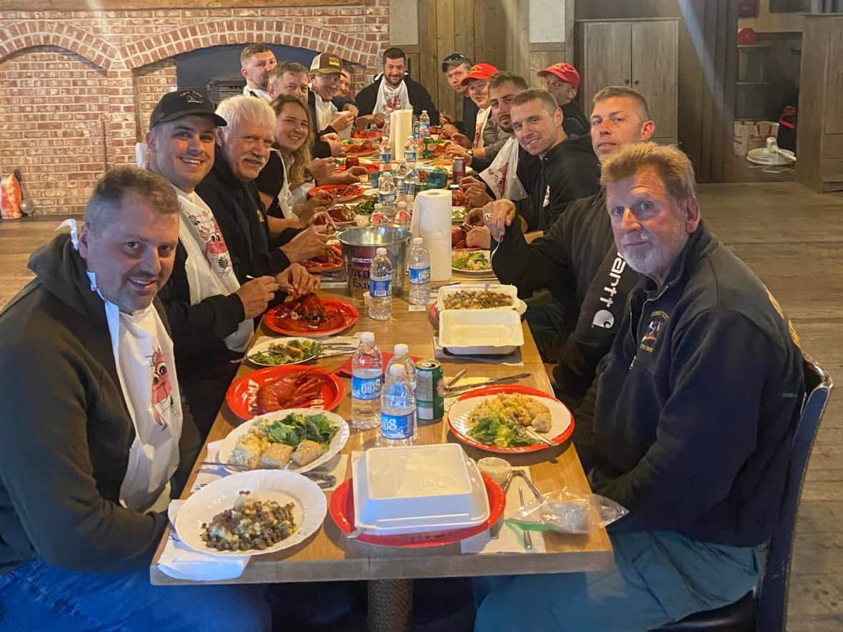 An American crew of firefighters are seen enjoying a lobster dinner put together by members of the Shelburne County community. (Nick Brand/Facebook - image credit)