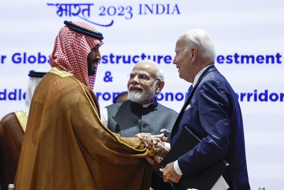 Saudi Arabian Crown Prince Mohammed bin Salman Al Saud, left, and U.S. President Joe Biden, right, shake hands next to Indian Prime Minister Narendra Modi on the day of the G20 summit in New Delhi, India, Sept. 9, 2023. (AP Photo/Evelyn Hockstein, Pool)