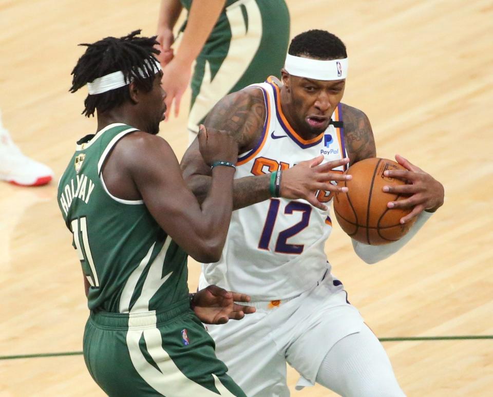Phoenix Suns forward Torrey Craig (12) is defended by Milwaukee Bucks guard Jrue Holiday (21) during Game 3 of the NBA Finals at Fiserv Forum July 11, 2021.